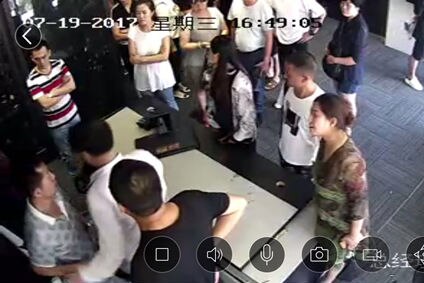 Office works crowd around a desk in a still image from security footage.