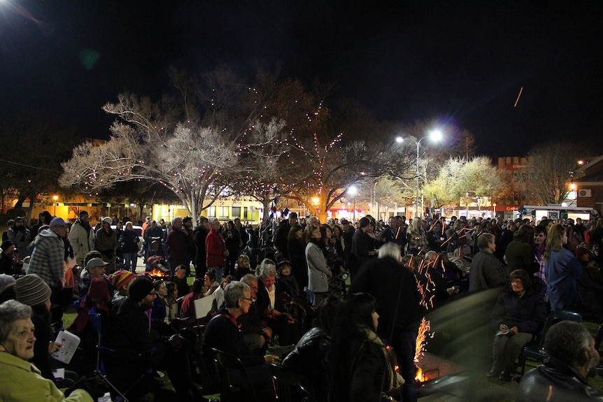 A large crowd of people in a public place at night.