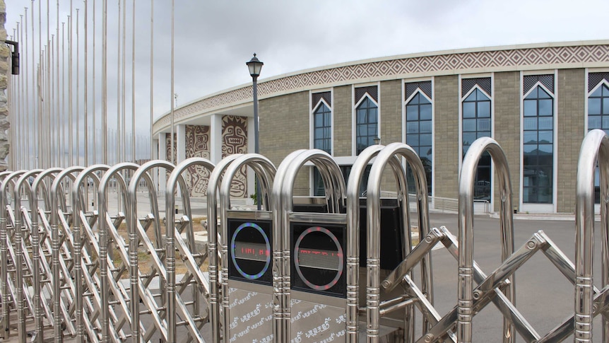 Port Moresby's International Convention Centre. A large circular building with electronic gates with Chinese characters.