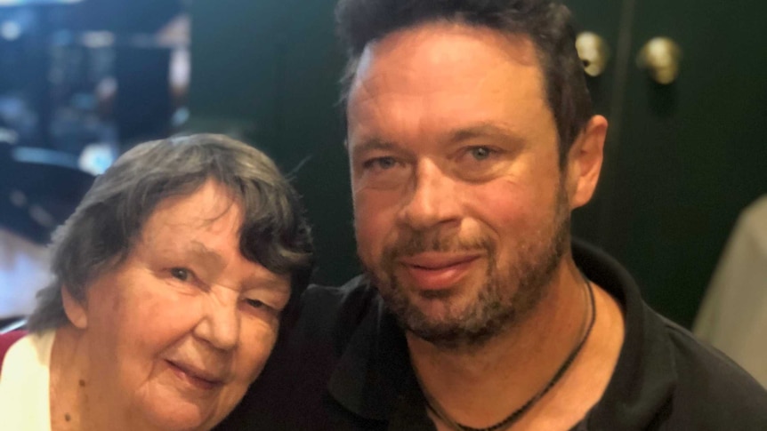 Robert McClintock puts his arm around an older woman