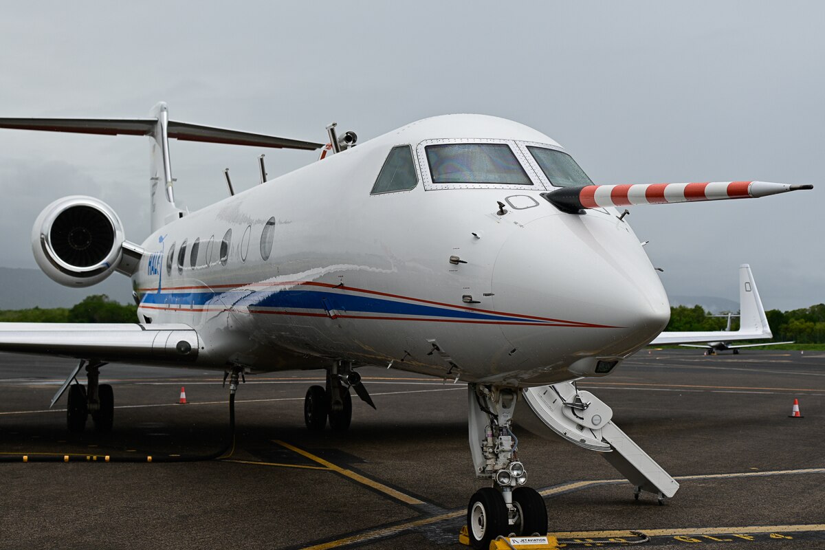 jet plane with custom fitted scientific measuring equipment on nose sits on tarmac