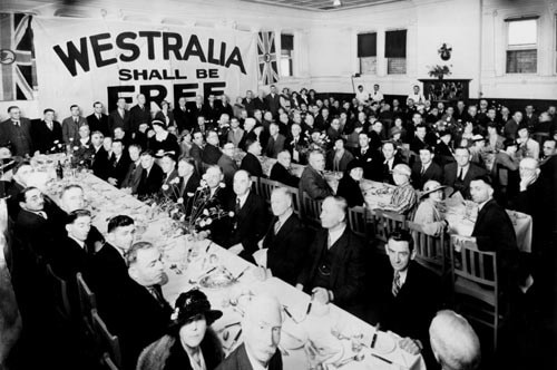 A black and white photograph of a large meeting of well dressed people.