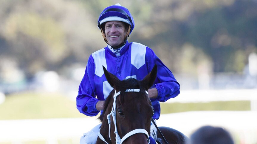 Jockey Hugh Bowman smiles sitting on top of Winx after her win in the Warwick Stakes.