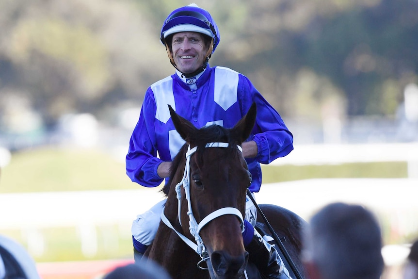 Jockey Hugh Bowman smiles sitting on top of Winx after her win in the Warwick Stakes.