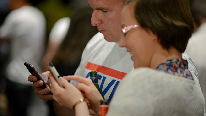 Siobhan Keating and Paul Watson look at the results for the 2013 Federal election on their phones.