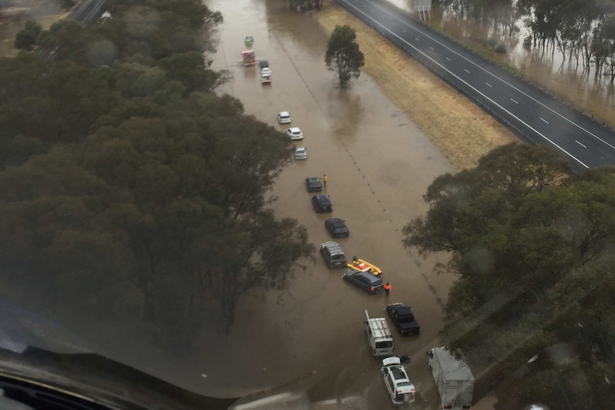Aerial image of cars stranded in brown floodwaters.