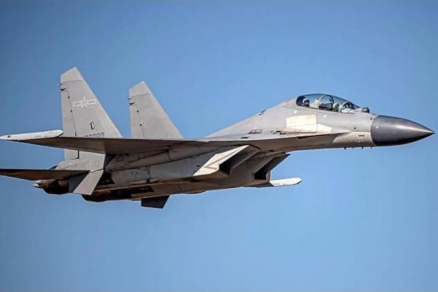 A fighter jet against a blue sky.