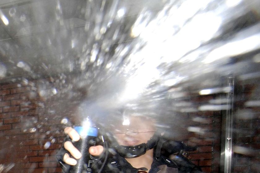 A policeman uses pepper spray