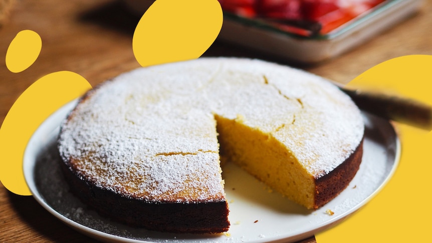 Lemon and almond yoghurt cake with roasted strawberries with a big slice cut out of it.