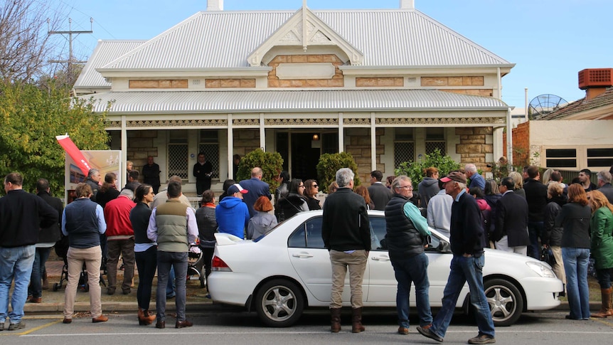 Crowd gathered outside a house at an auction