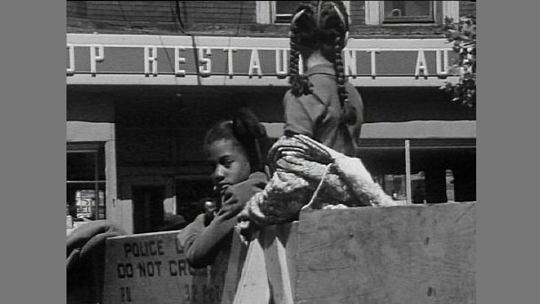 Two African-American girls stand in street