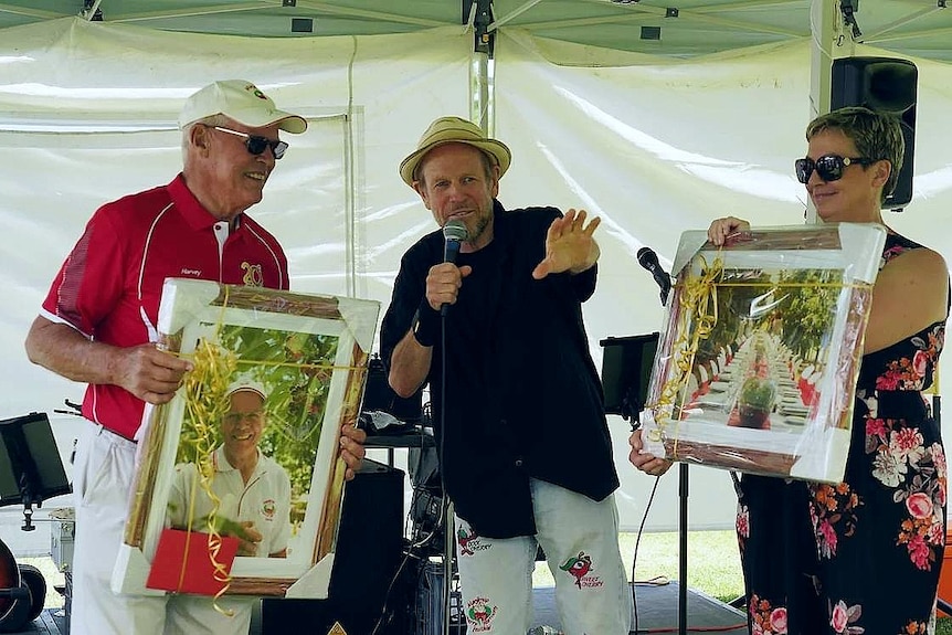 A man auctioning off some paintings