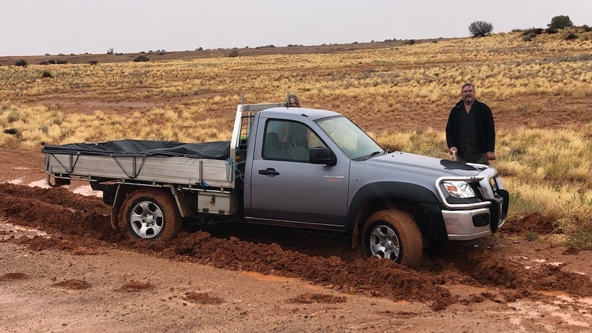 A ute bogged in red dirt.