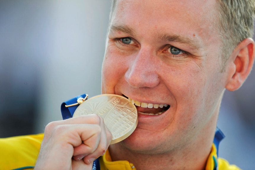 Olympic swimmer for Australia Brenton Rickard bites his gold medal on the podium in Rome, July 2009.