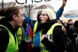 Protesters wearing yellow vests demonstrate in the streets.