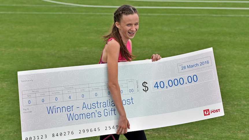Talia Martin poses with an oversized novelty cheque for $40,000 after winning the women's Stawell Gift on March 28, 2016.