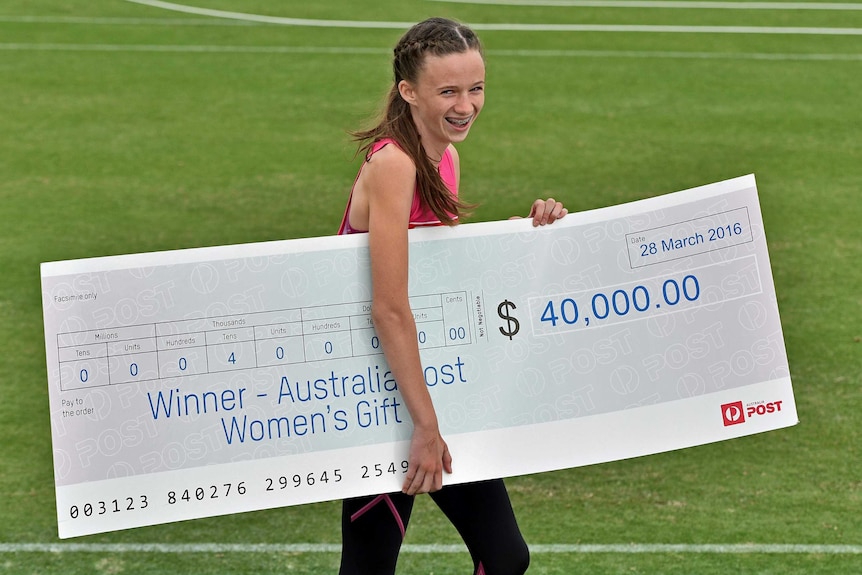 Talia Martin poses with an oversized novelty cheque for $40,000 after winning the women's Stawell Gift on March 28, 2016.