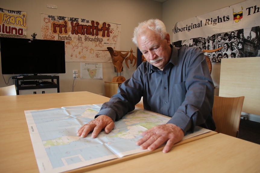 Michael Mansell looks at a big map on a table.