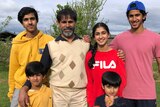 Dr Iqbal Zafar stands outside with five children