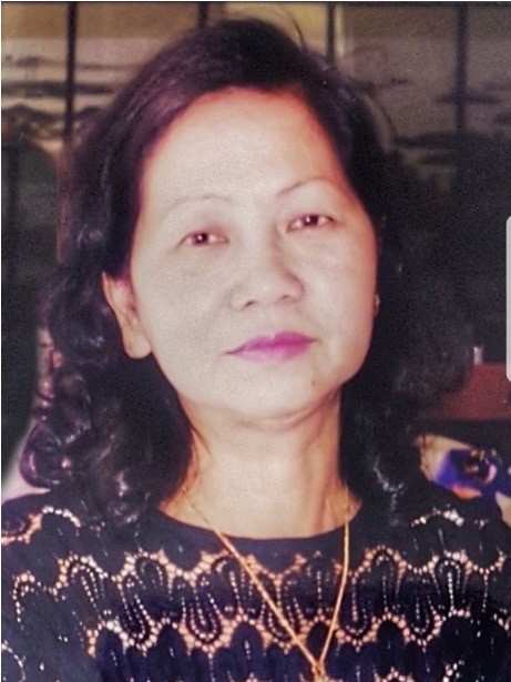 A portrait photograph of Le Ngoc Le who is wearing a gold necklace and black and gold top.