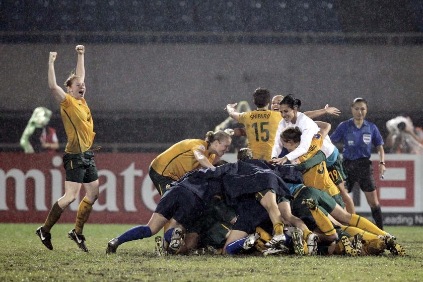 Matildas players pile on to one another after winning the 2010 Asian Cup