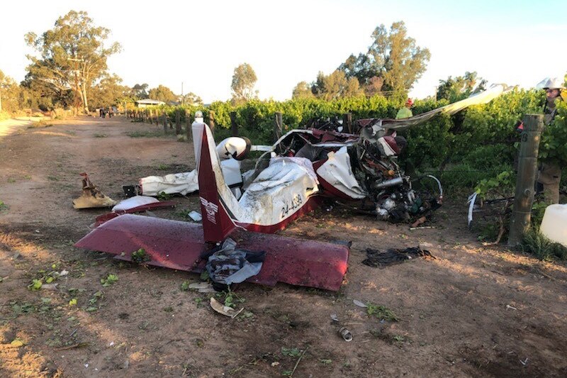 A crashed and damaged white and red light plane on the ground