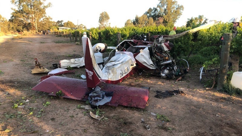 A crashed and damaged white and red light plane on the ground