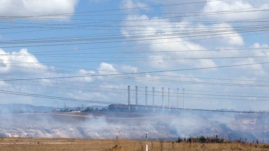 Hazelwood power plant from a distance, with power lines in the foreground