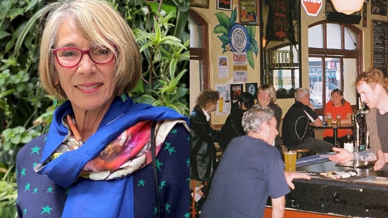 womanwith blonde bob, red spectacles and scarf with leaves in background and men sitting at a bar