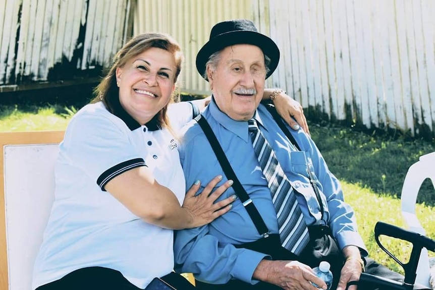 a woman smiling with her arms wrapped around her father