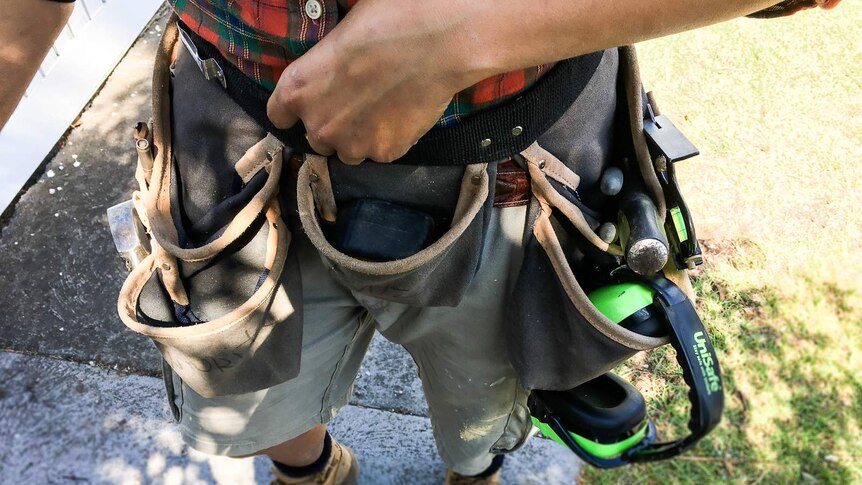 A tradesman wearing a toolbelt.