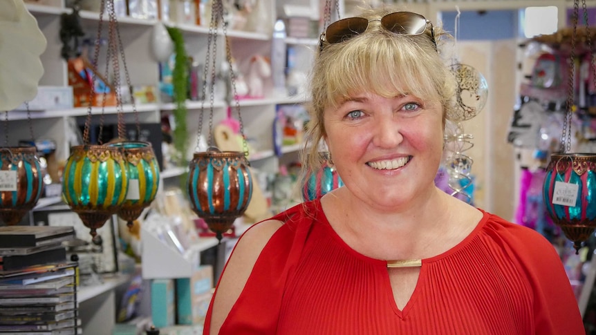 Coolah gift shop owner Liz Austin standing behind her counter with colourful giftshop items in the background