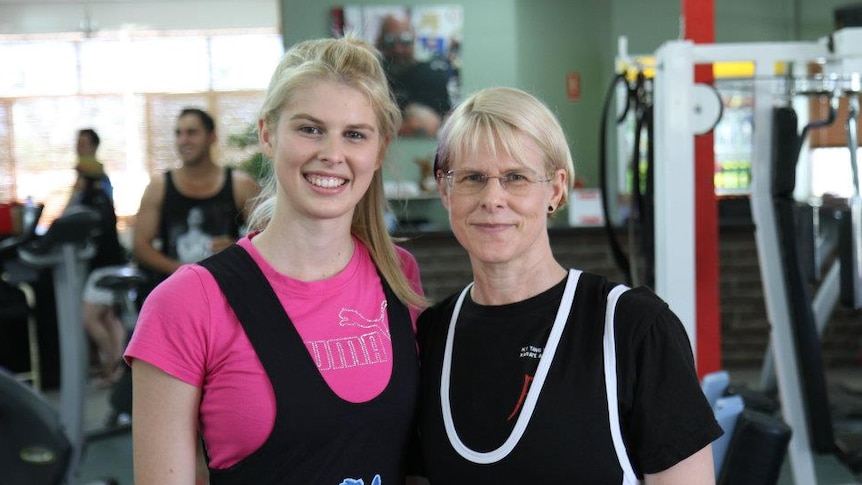 A middle-aged mother with her daughter at a weightlifting gym in Darwin.