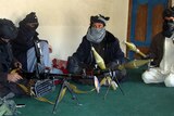 Taliban fighters display their weapons
