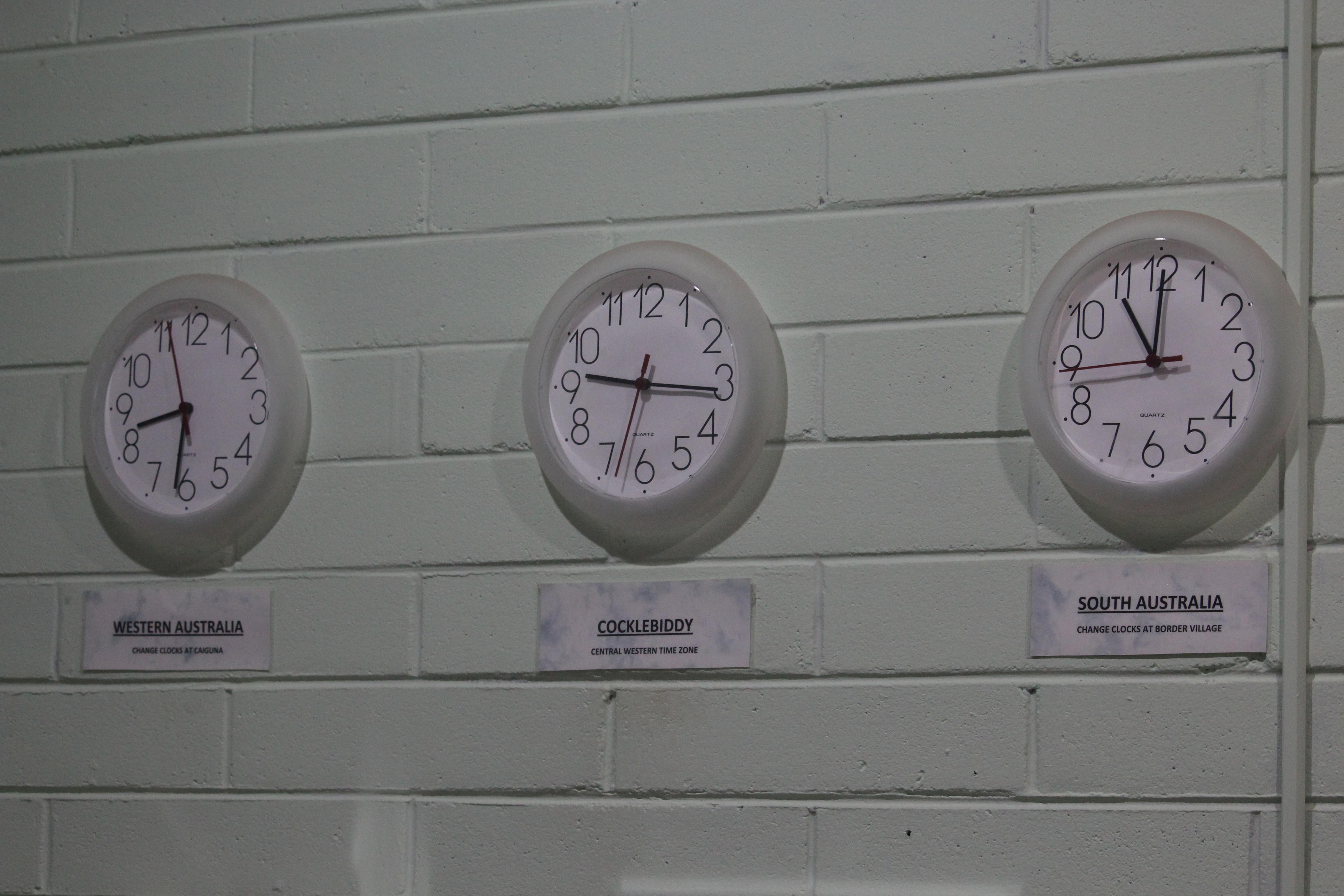 Three analogue clocks showing different time zones.