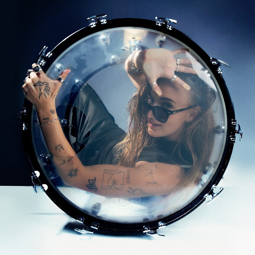 a person wearing sunglasses is stuck inside a kick drum