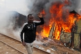 A man runs past a burning shack in a Kenyan slum.