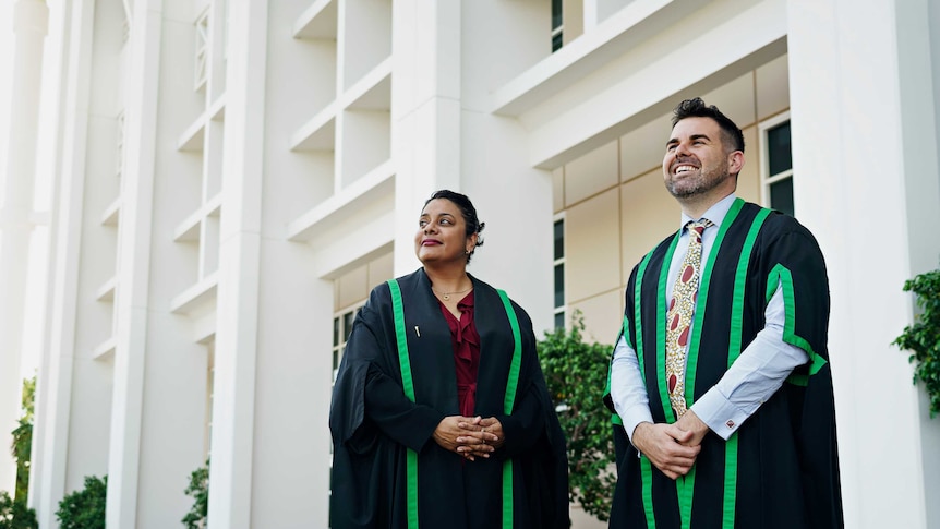 Chansey Paech and Ngaree Ah Kit are wearing speakers robes outside NT Parliament. They are smiling.