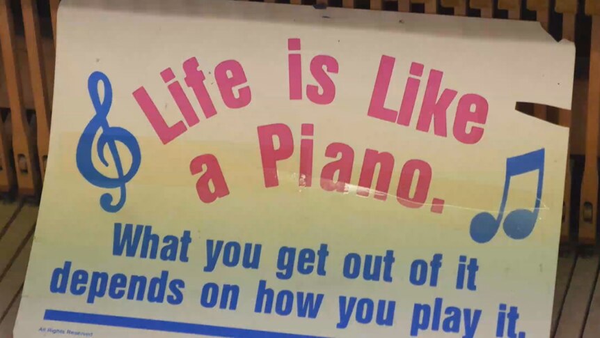 A sign that reads: "life is like a piano: what you get out of it depends on how you play it"