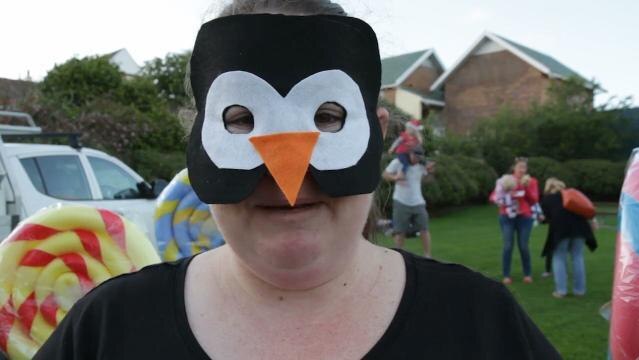 Woman wears penguin mask