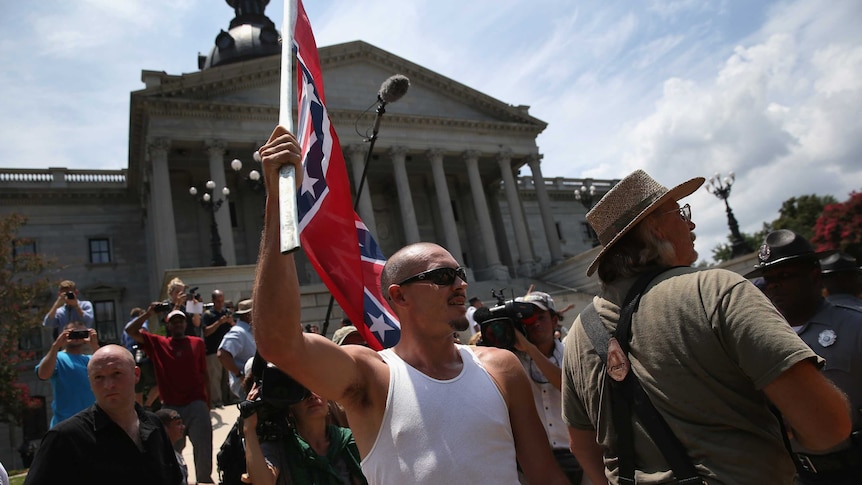 White supremacists from the White Knights of the Ku Klux Klan protest over the Confederate flag's removal from the state building