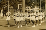 A black and white photo group of Indigenous girls on parade as part of the Cherbourg marching girls in Melbourne 1962.