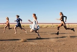 Five women running on the dusty Maxwelton race track.