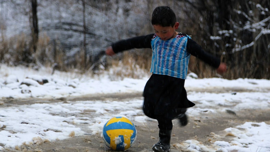 Afghan Lionel Messi fan Murtaza Ahmadi, 5, wears a plastic bag jersy as he plays football