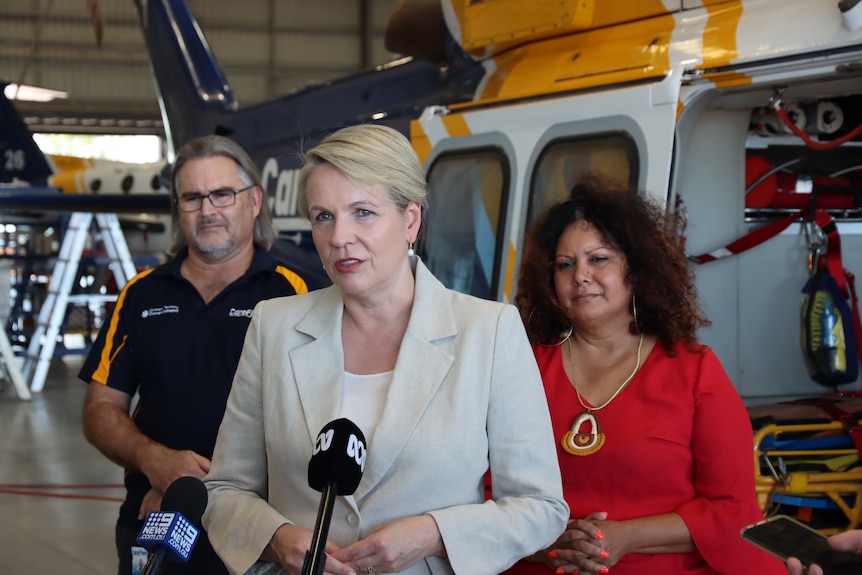 Tanya Plibersek speaks at a press conference in front of a Careflight helicopter. Malarndirri McCarthy stands behind her.