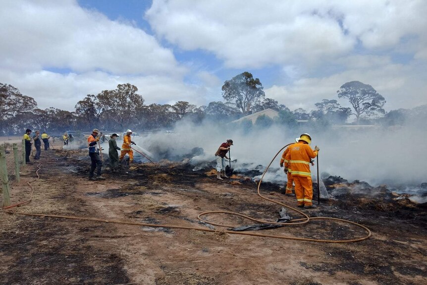 CFS firefighters damp down smouldering hay.