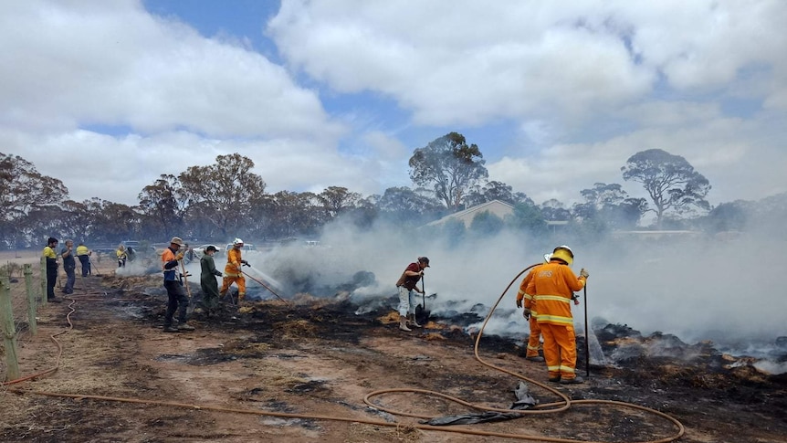 CFS firefighters damp down smouldering hay.