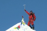 Canberra mountaineer Andrew Lock raises his pick on top of a summit
