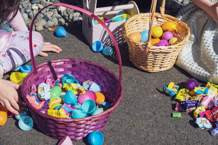 A basket with easter eggs and a girl's hands.