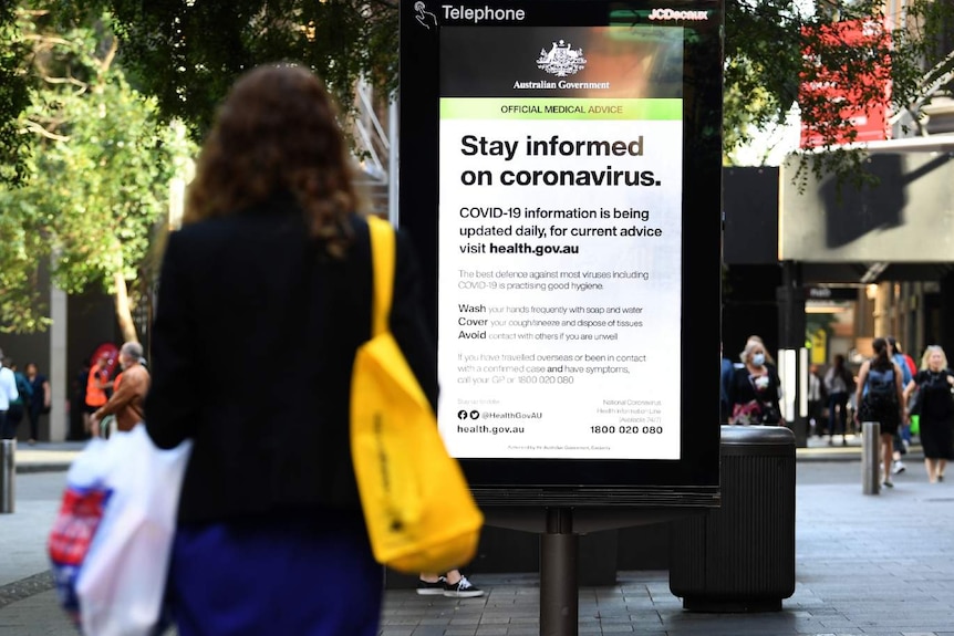 Two people in front of a sign